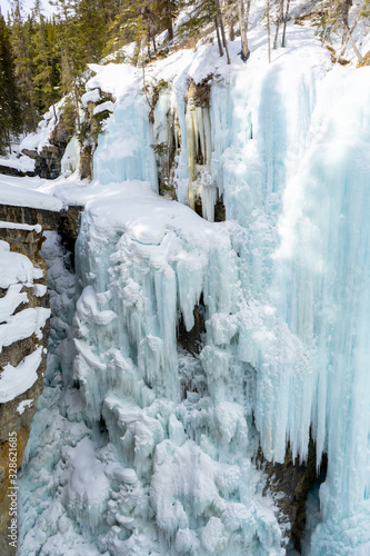 Frozen upper falls at Johnston Canyon Trail in winter, icy waterfalls landscape view. Banff National Park, Alberta, Canada