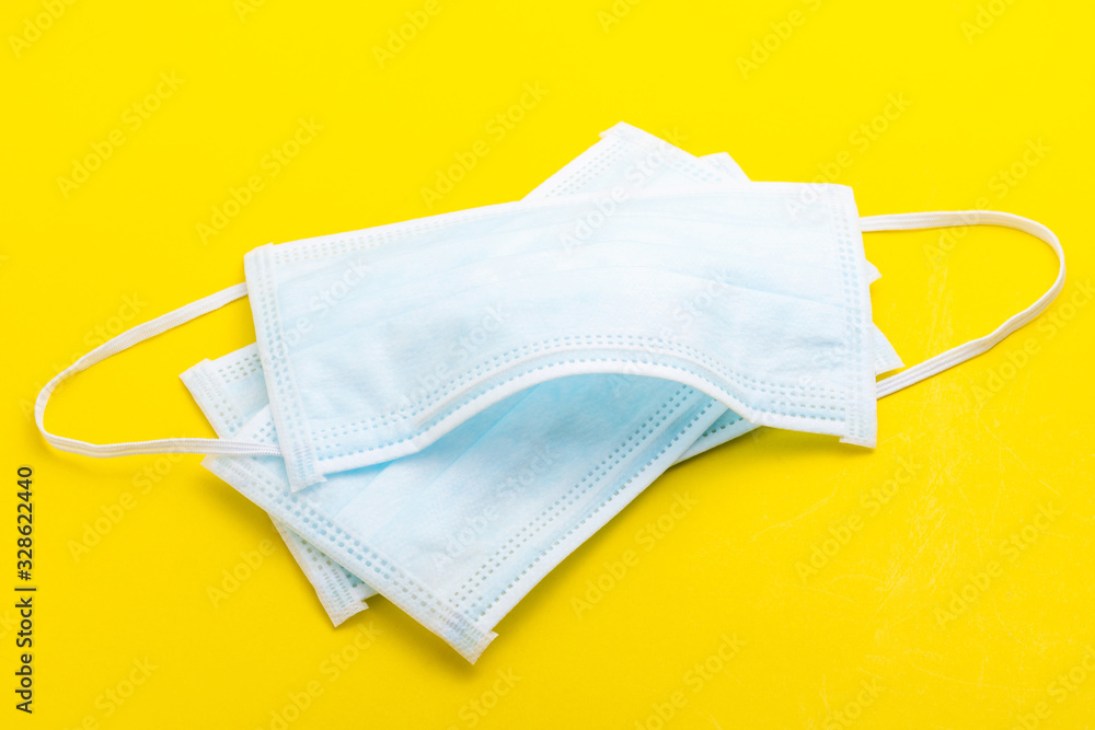 New white mask on yellow background. .Mask is important but lack and very expensive in many country of Virus situation in 2020 New white mask on yellow background. .Mask is important but lack and very expensive in many country of Virus situation in 2020