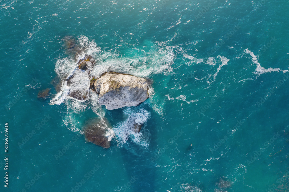 Aerial view of waves and sea rocks.