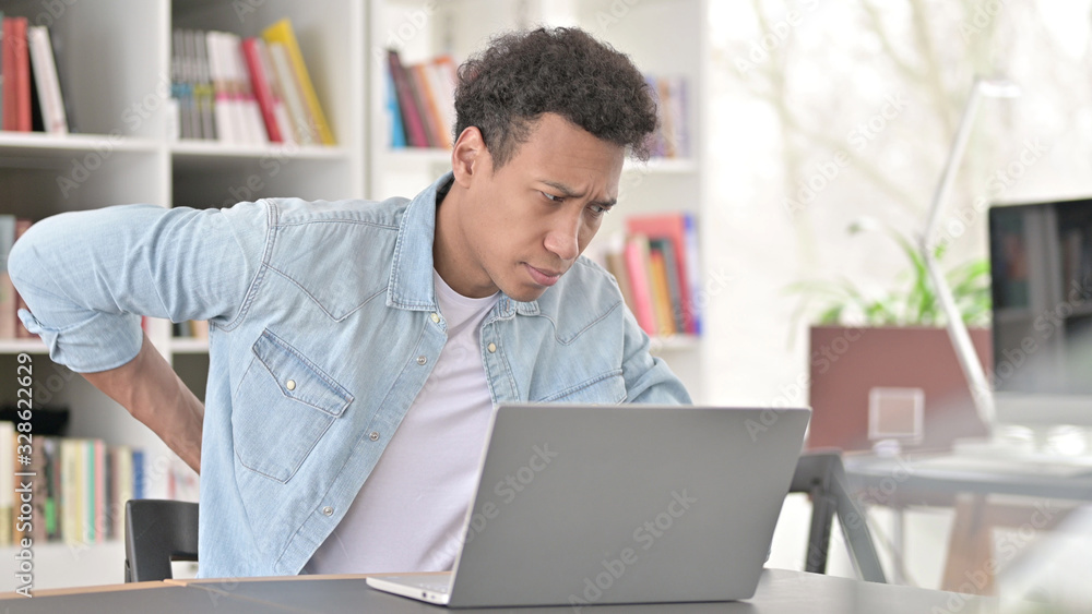 Exhausted Young African American Man having Back Pain at Work Exhausted Young African American Man having Back Pain at Work