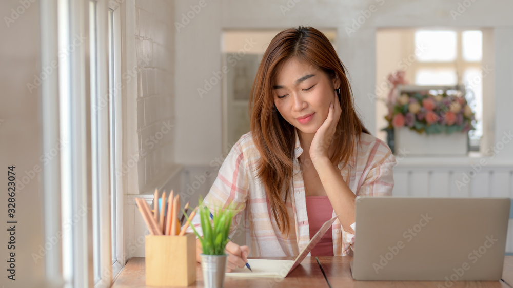 Close up view of college girl focusing on her assignment with laptop Close up view of college girl focusing on her assignment with laptop