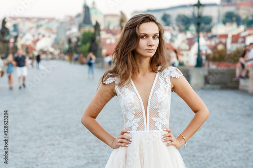 Young bride in a beautiful dress walks on the bridge