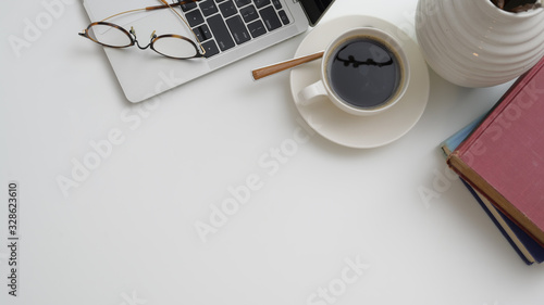 Top view of workplace with laptop, coffee cup, books and copy space photo