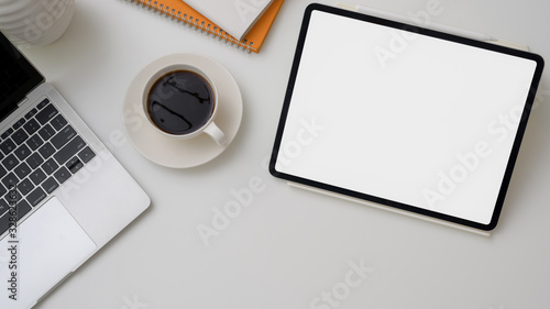 Top view of workplace with mock-up tablet, laptop and coffee cup