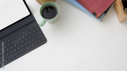 Overhead shot of workplace with mock-up tablet, coffee cup, stationery and copy space photo