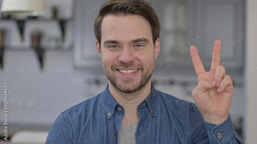 Portrait of Young Man showing Victory Sign Portrait of Young Man showing Victory Sign