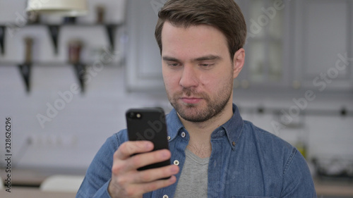 Portrait of Beard Young Man using Smartphone