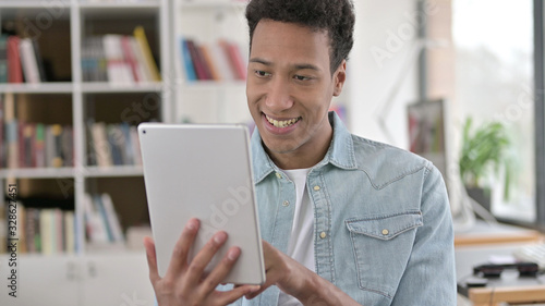 Smiling Young African American Man using Digital Tablet