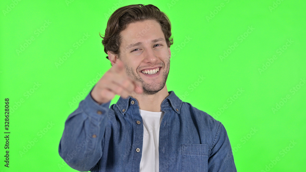 Cheerful Young Man Pointing at the Camera on Green Chroma Key Cheerful Young Man Pointing at the Camera on Green Chroma Key