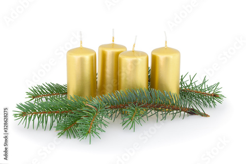Advent candles with coniferous twigs. Isolated on white background with natural shadow. Composition of advent candles of gold color and coniferous twigs. Christmas candles with branches on white bg.