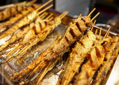 Grilled fish on wooden sticks.