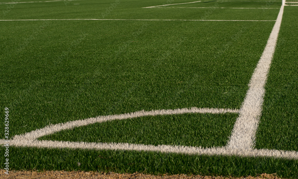 Artificial green grass and white border lines. Artificial turf for soccer field. Football field in an outdoor stadium. Selective focus Artificial green grass and white border lines. Artificial turf for soccer field. Football field in an outdoor stadium. Selective focus