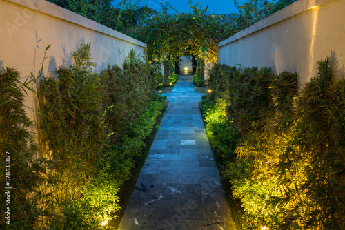 Garden path in resort with warm light and trees on side at evening, Garden Decoration.