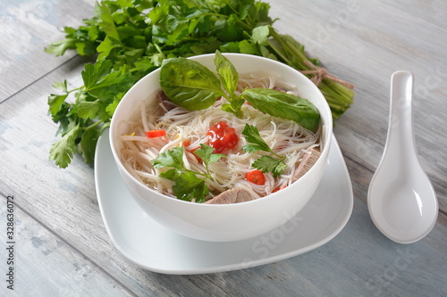 Traditional Vietnamese soup Pho bo with herbs,beef, rice noodles,chili and bean sprouts . Vietnamese Cuisine. Asian food photo