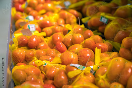 Fresh healthy fruits on shelves in supermarket. Ripe tomato