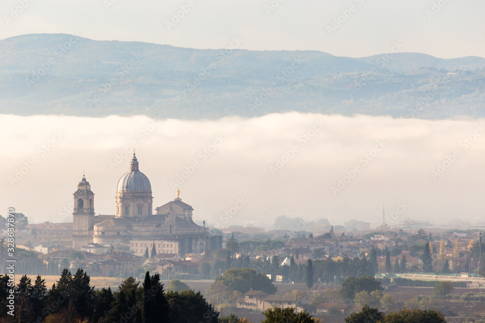 Surreal view of Santa Maria degli Angeli papal church (Assisi) on a background of fog