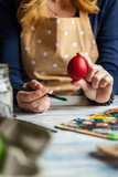 Woman wearing apron and coloring Easter eggs