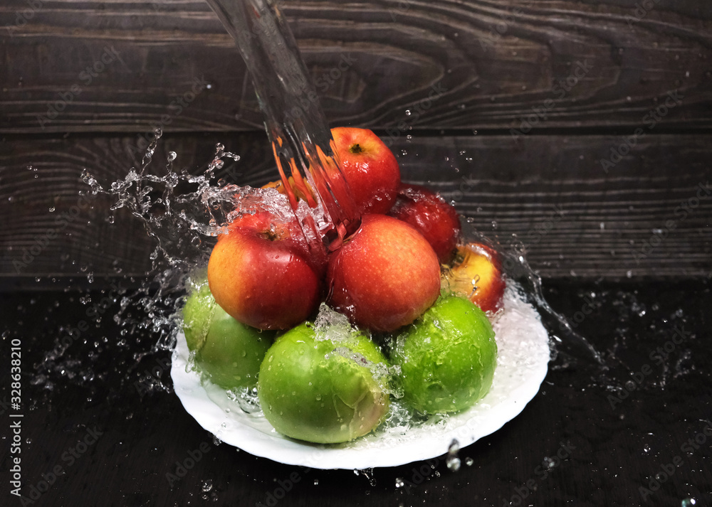 Naklejka premium green and red apples are washed under a powerful stream of water, frozen drops of water,