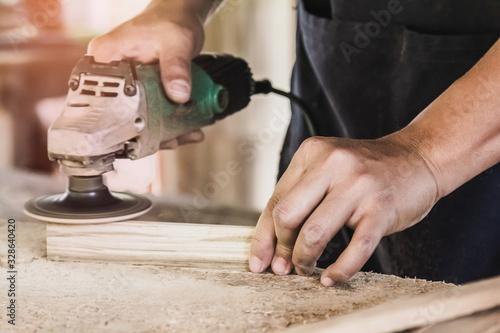 Carpentry is using an electric sander, to smoothen the wood texture. Small business woodworking