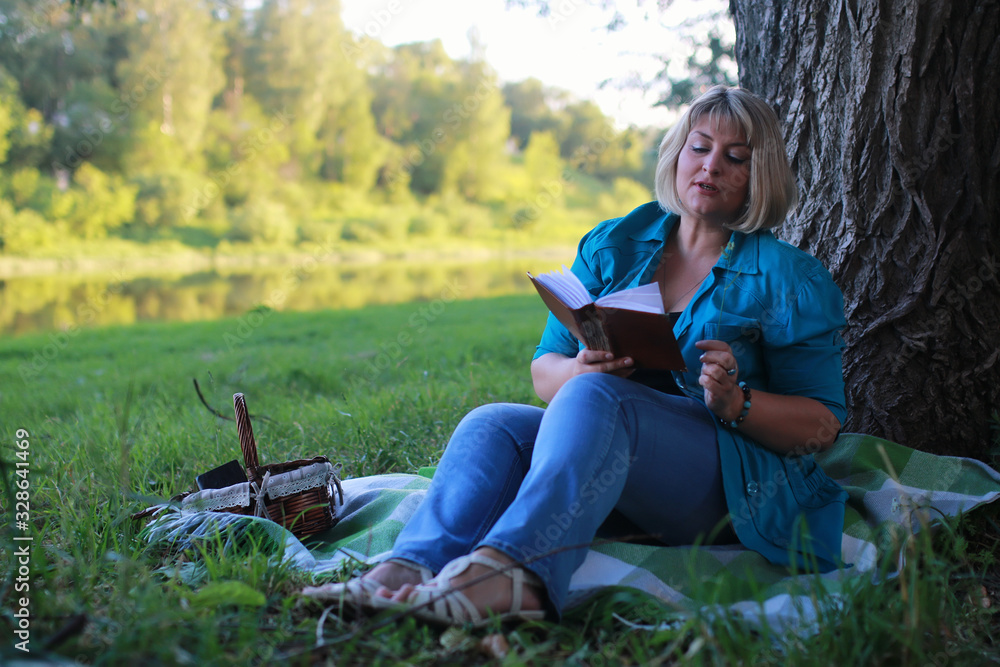 Obraz premium woman in park with book on the grass