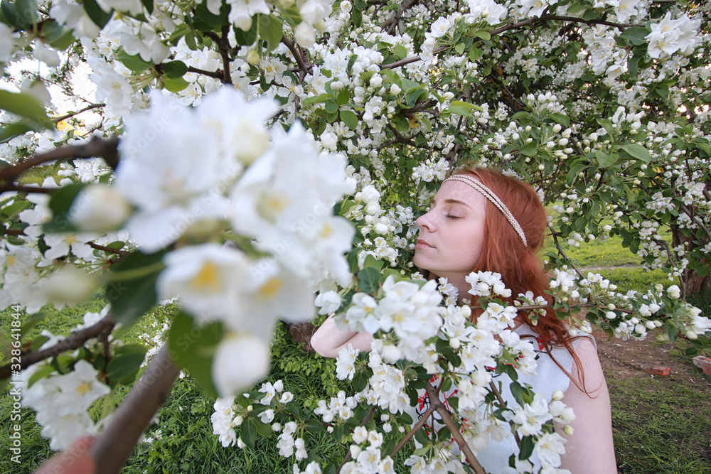 Fototapeta premium A girl on a walk in an autumn park. Young red-haired girl in the spring on nature.