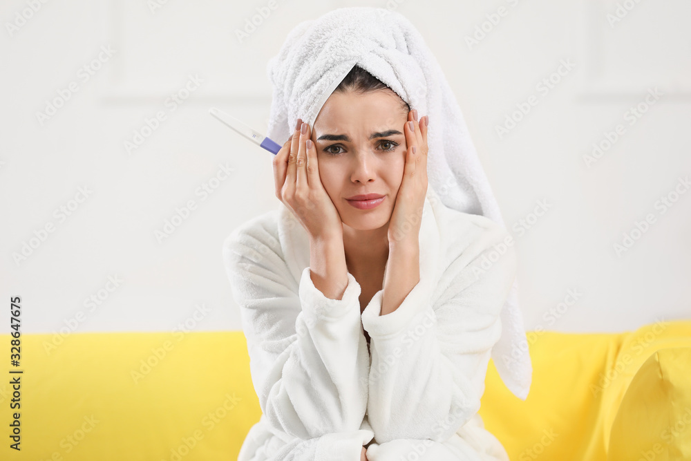Sad young woman with pregnancy test at home Sad young woman with pregnancy test at home