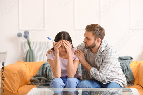 Sad young couple with pregn...