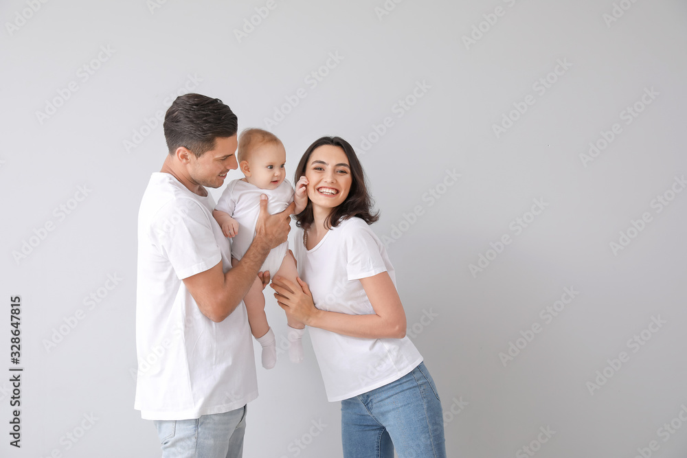Cute baby with parents on light background Cute baby with parents on light background