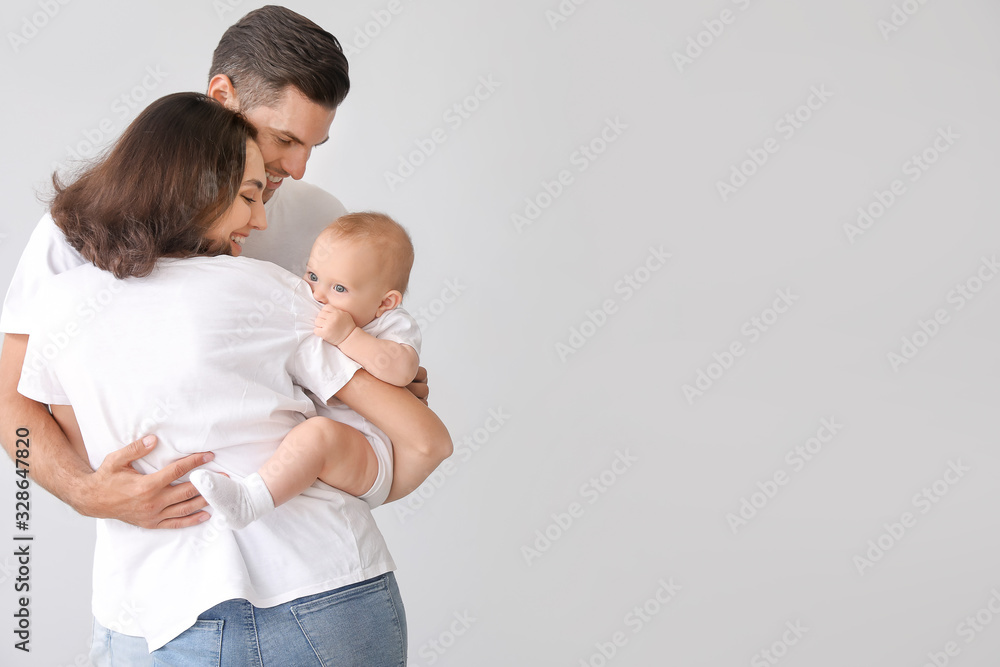 Cute baby with parents on light background