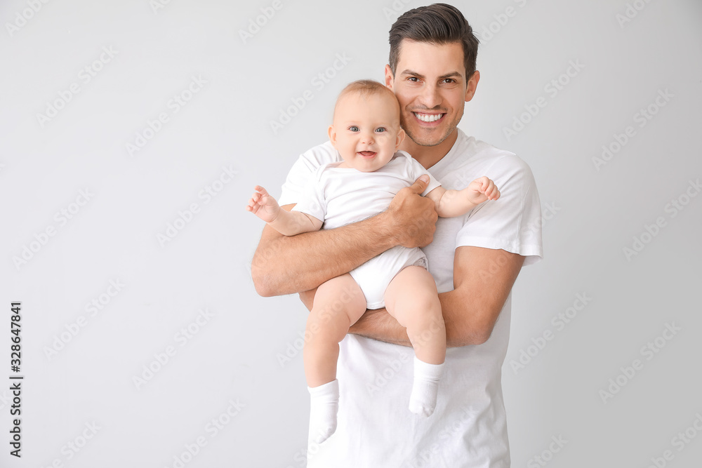 Cute baby with father on light background Cute baby with father on light background