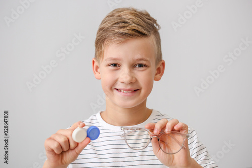 Photography Little boy with contact lens case and eyeglasses on grey background
