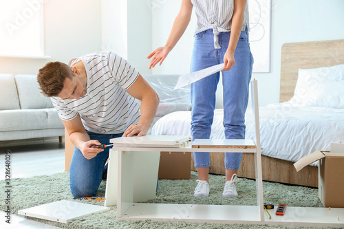 Quadro em tela Young couple assembling furniture at home