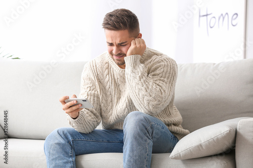 Sad man with mobile phone a...