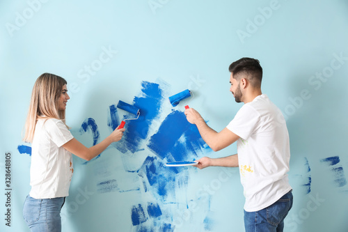 Happy young couple painting...