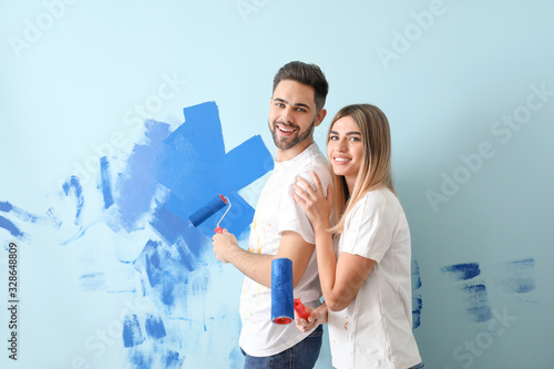 Happy young couple painting...