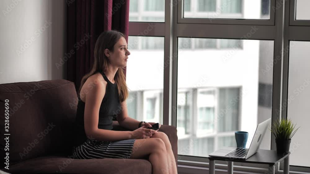 Upset young woman sitting on couch, holding smartphone in hands, received message with bad news. Stressed 20s lady thinking over sudden problems after reading sms on cellphone. 4k Upset young woman sitting on couch, holding smartphone in hands, received message with bad news. Stressed 20s lady thinking over sudden problems after reading sms on cellphone. 4k