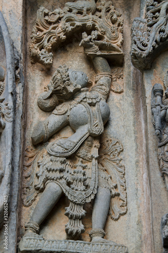 Carved idol on the outer wall of Kedareshwara Temple is a Hoysala era construction, Halebeedu, Karnataka, India