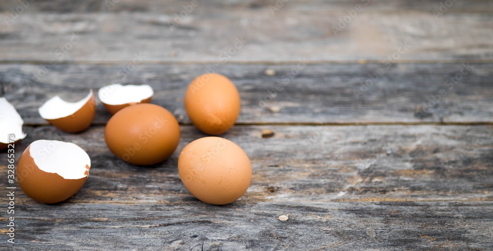 Eggs and egg shells placed on a wooden plate, leaving an empty space on the right. Eggs and egg shells placed on a wooden plate, leaving an empty space on the right.