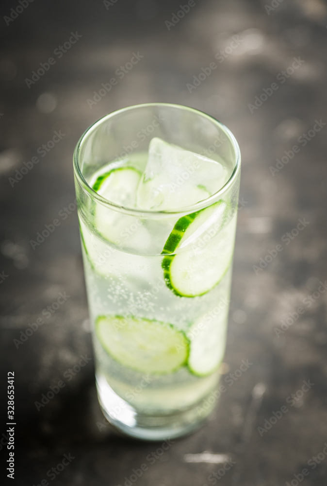 Detox beverage with cucumber slices on the rustic background. Selective focus. Shallow depth of field. Detox beverage with cucumber slices on the rustic background. Selective focus. Shallow depth of field.