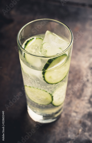 Detox beverage with cucumber slices on the rustic background. Selective focus. Shallow depth of field.