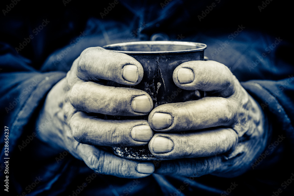 Working men's hands. A man holds a metal mug in his hands.