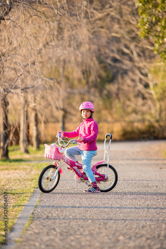春の公園で自転車を乗って遊んでいる子供
