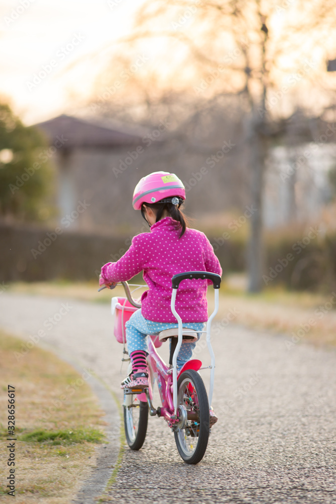 春の公園で自転車を乗って遊んでいる子供