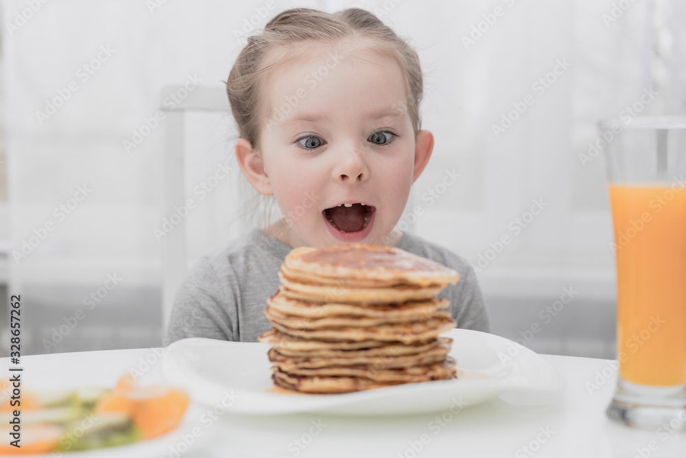 Young crazy little girl eating a stack of pancakes Young crazy little girl eating a stack of pancakes