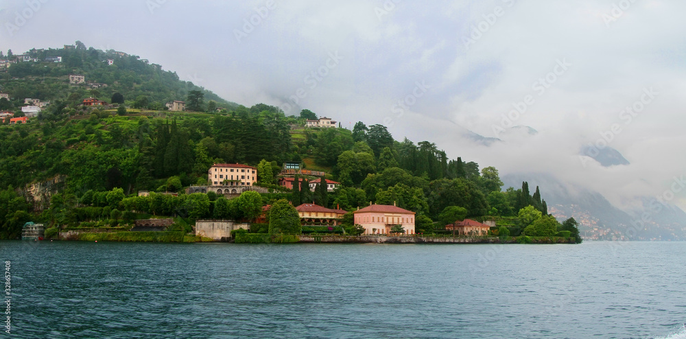 Panoramic view of Como lake with villages and mountains shrouded in clouds. Cernobbio. Italy.