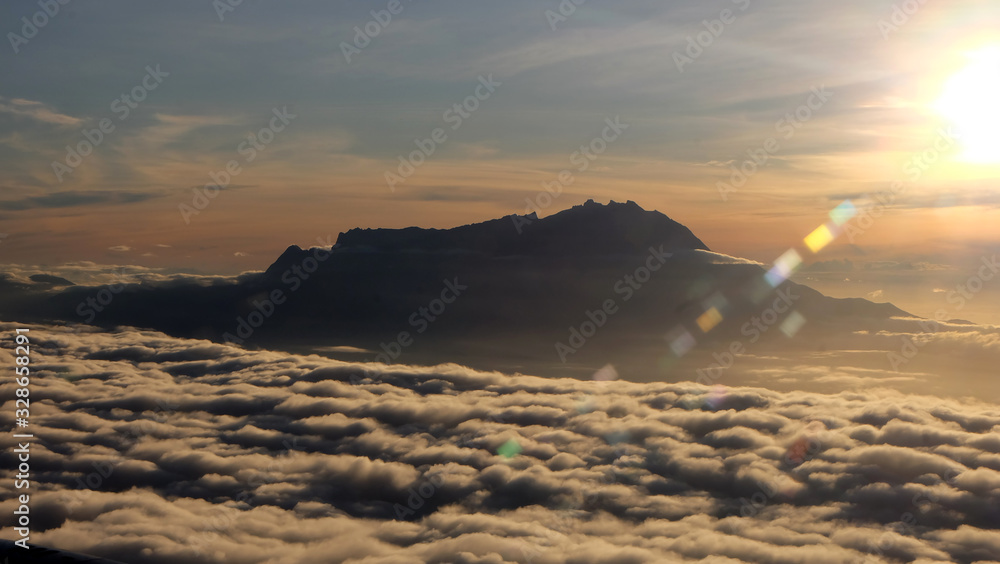 View of the peak of Mount Kinabalu, Sabah, Malaysia, surrounded by sea of clouds, in the morning sun.