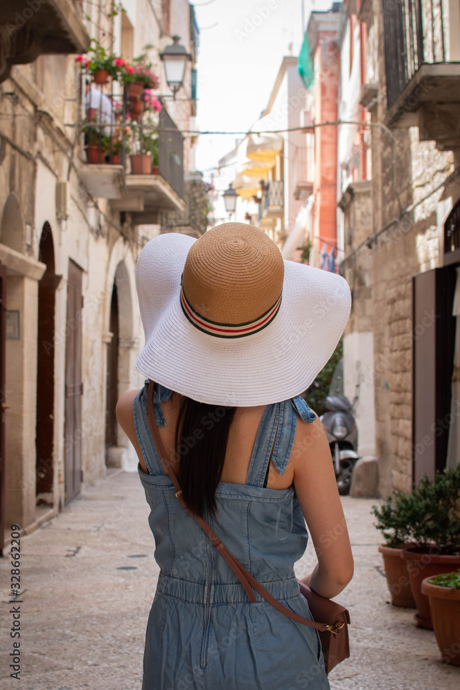 Jeune fille avec un chapeau de plage dans le centre ville de Bari, Sud d'Italie