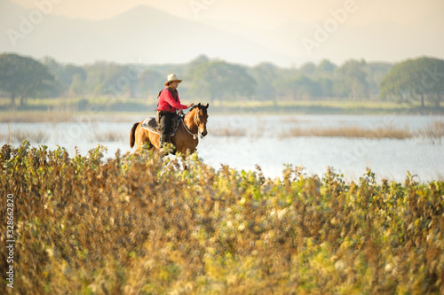 Western cowboys riding horses along the river.