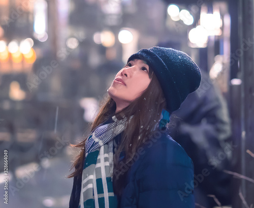 Portrait of Female tourist traveling in Ginzan Onsen with snow falling at night photo