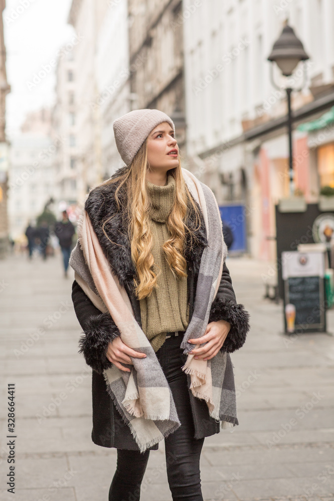 Beautiful young woman in winter autumn outfit walking in the city street Beautiful young woman in winter autumn outfit walking in the city street